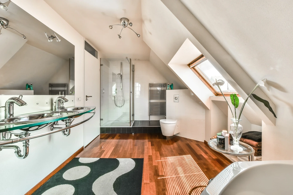Przytulna łazienka na poddaszu z drewnianą podłogą, podwójną umywalką i prysznicem – remont łazienki