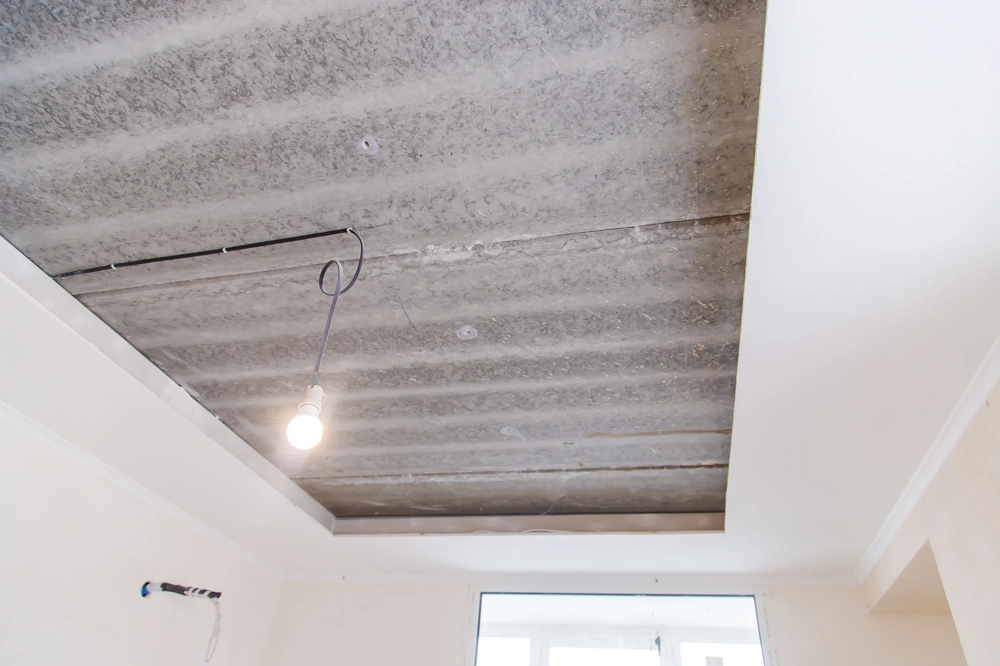 Sufit podwieszany z płyt G-K z widoczną konstrukcją i tymczasowym oświetleniem