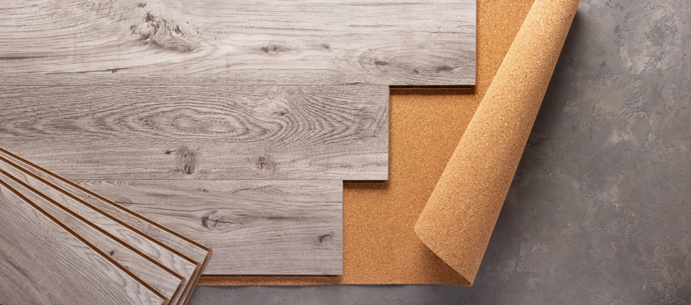 Układanie paneli podłogowych – jasne panele na podkładzie korkowym gotowe do montażu